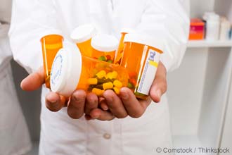 pharmacist with prescription bottles