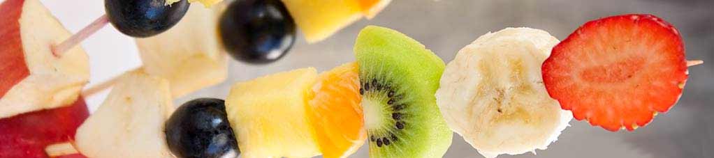 Farbenfrohe Fruchtspieße mit Kiwis und Kokosnussjoghurt