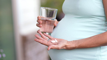 Schwangere nimmt Vitamine ein