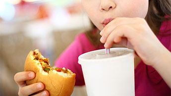 criança comendo em fast food